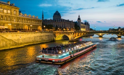 bateau mouche cruising on seine river at sunset, paris.