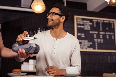 man using mobile payment in a coffee shop