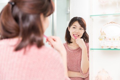 young attractive asian woman with healthy teeth holding a tooth brush
