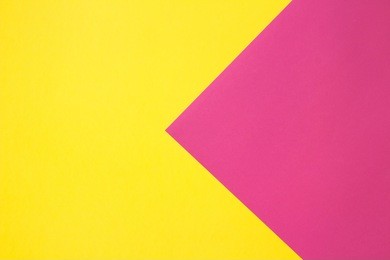 coloured paper in geometric flat composition. pink and yellow colors. large arrow