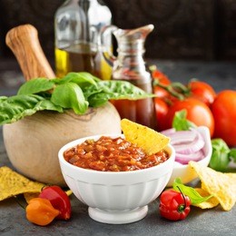 homemade spicy tomato salsa with vegetables, herbs and olive oil