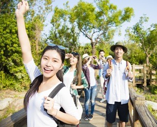 happy young group hiking together through the forest