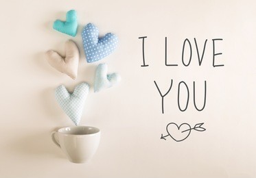 i love you message with blue heart cushions coming out of a coffee cup