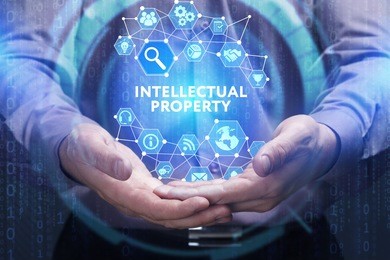 business, technology, internet and network concept. young businessman shows the word on the virtual display of the future: intellectual property