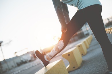 woman doing legs stretching. workout in industrial area. warming sport exercise
