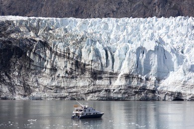the little boat exploring the glacier in glacier bay national park (alaska).