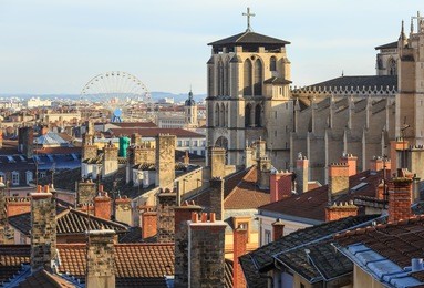 rooftops, chimneys and cathedral of the old town vieux lyon, with ferris wheel in the background. lyon, france.