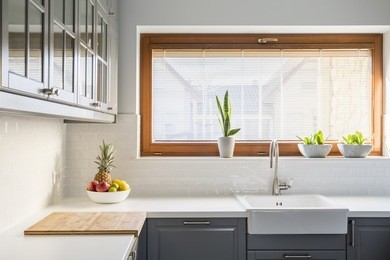 light kitchen with white countertop, sink, window and grey furniture