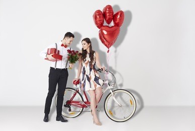 young man bestowing woman by gift and roses 