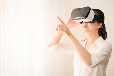 woman in vr headset looking up at the objects in virtual reality. mixed race asian chinese model.