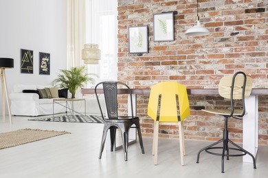 modern apartment with brick wall, dining table, chair and sofa