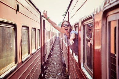 cheerful woman looking out the window of the old train