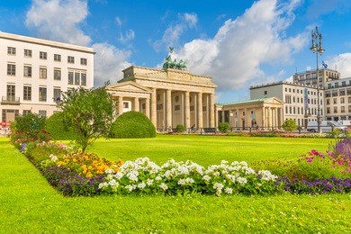 classic view of famous brandenburg gate at pariser platz, one of the best-known landmarks and national symbols of germany, on a beautiful sunny day in summer, central berlin, germany