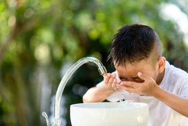 selective focus and brand new faucet and kid hand taking water.