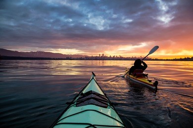 kayakers enjoying the beautiful sunrise. picture taken near kitsilano beach, vancouver, bc, canada.