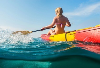 young woman on kayak  in sea with blue sky background. split photo.