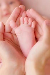 mother holding her child's small feet in her hands