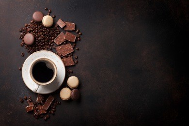 coffee cup, beans, chocolate and macaroons on old kitchen table. top view with copyspace for your text 