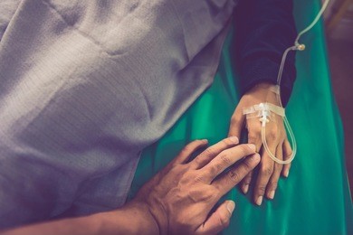 closeup of loving couple holding hands while sick , hand of man touching woman in clinic , holding hands retro background, closeup