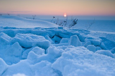 pink sunset in winter. frozen river. blue snow. minimalism.
