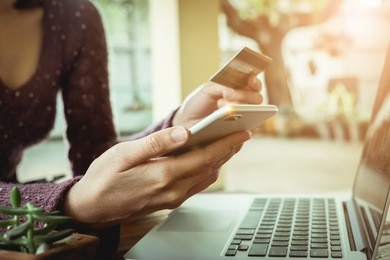online payment,woman's hands holding smartphone and using credit card for online shopping.