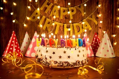happy birthday cake with candles on the background of garlands a