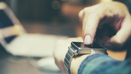 in hall station a man using his smart watch app. close-up hands
