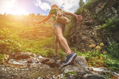 hiking sporty girl runs along the water into the mountains. running woman. 