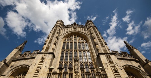 bath abbey with blue sky and clouds above