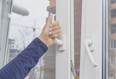 woman's hand opening a window