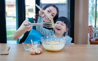 young beautiful mother teaches daughter prepare dough in the kitchen.concept family happy.