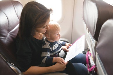 mother and her daughter  checking safety  in economy class airliner 