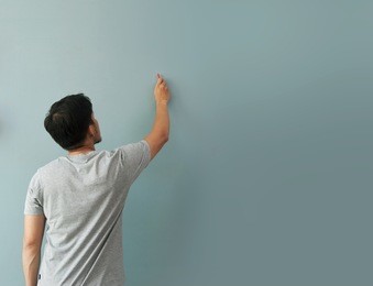 man drawing gesture with white chalk on chalkboard or wall. copy space, blank space.
