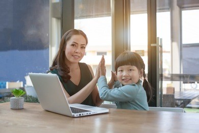 little girl looking at laptop computer with her mom.concept family happy.