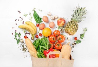 paper bag of different health food on a white background. top view. flat lay