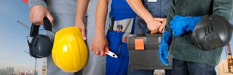 workers closeup with equipment on building background