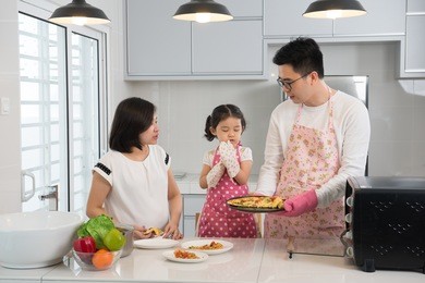 asian family enjoying and cooking pizza