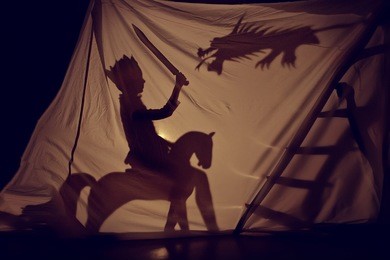 fabulous the shadow of the little prince on horse with sword and dragon. theatre. childhood. tale.