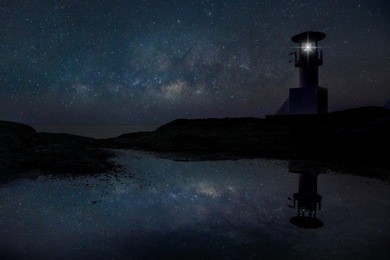 the milky way galaxy over a lighthouse