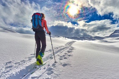 girl makes ski mountaineering alone toward the mountain pass in a nice track with sealskin