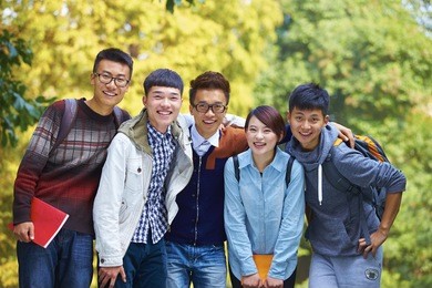 five happy chinese college students smile at camera in campus