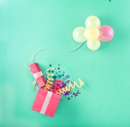 red gift box with various party items and balloons. celebration background. top view