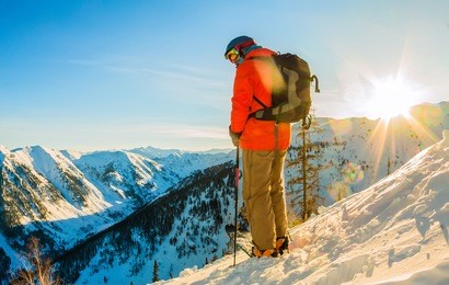 freerider skier descends from the mountain in the light of the morning sun.