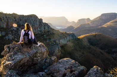 a girl sitting on a rock at lowveld view in blyde river canyon nature reserve (motlatse canyon provincial nature reserve) in mpumalanga, republic south africa. 