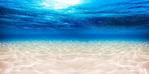 underwater blue ocean wide panorama background with sandy sea bottom