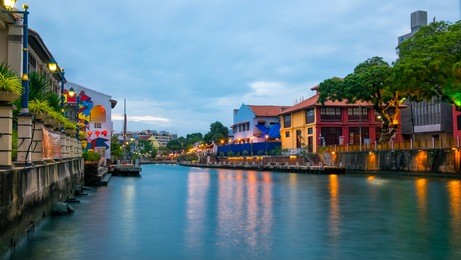 stunning langscape of malacca river at the evening time. light of street lanterns reflecting in the river. colorful houses on both sides of the river. travel malaysia