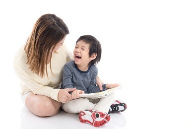 asian mother and her son reading a book together on white background isolated