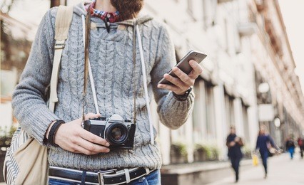 traveler man using mobile phone in the street. active lifestyle and travel concept