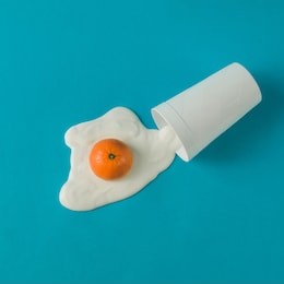 creative breakfast layout. orange and yogurt fried egg. flat lay. food concept