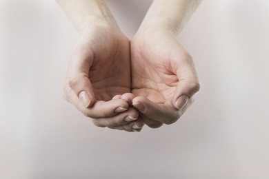 close up of womans cupped hands showing something